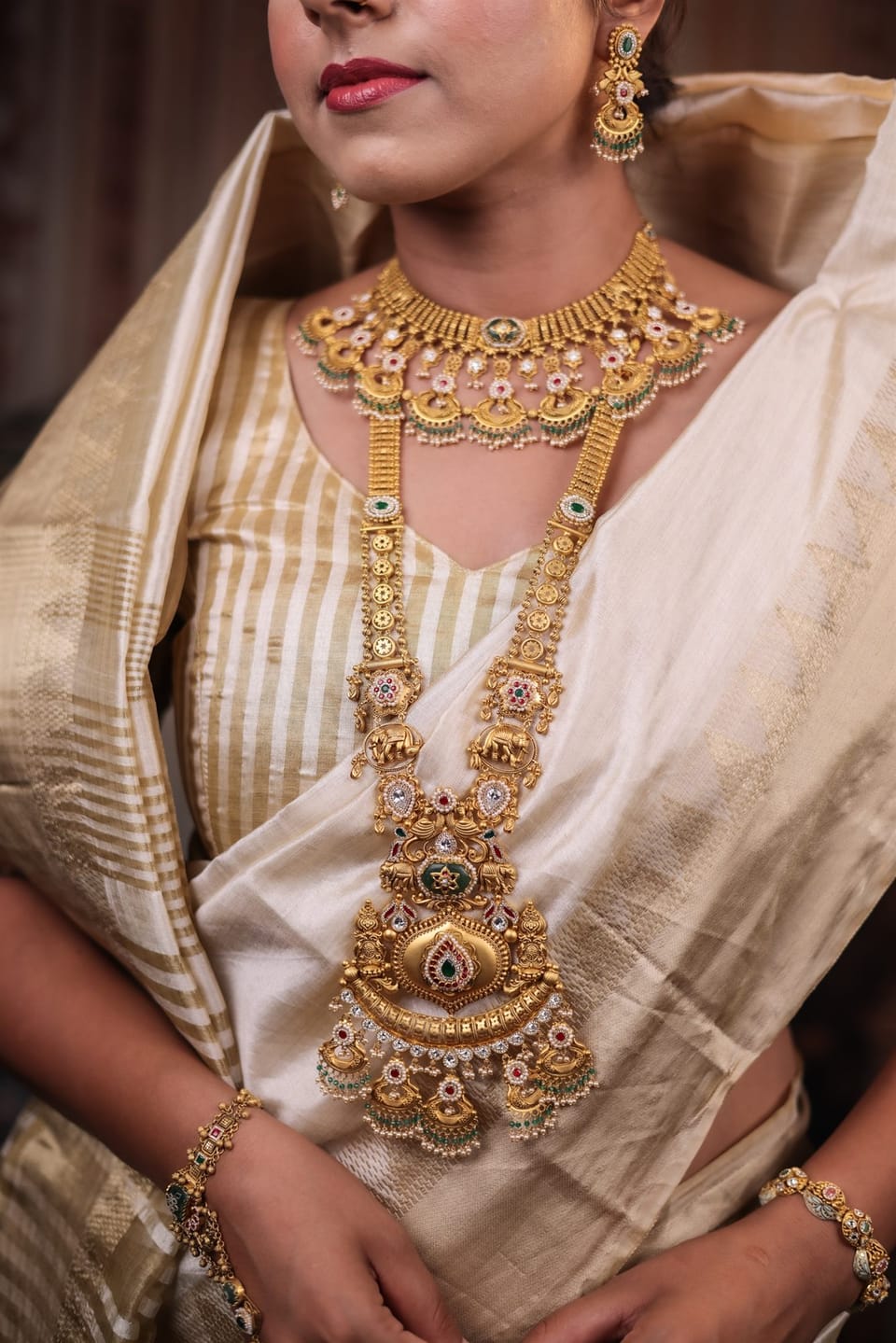 Bride in a gold temple necklace set with emerald drops, Shree Jewels Porbandar