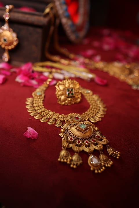 Ornate antique gold temple pendant styled with rose petals, Shree Jewels Porbandar